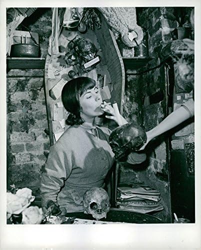 Гроздобер фотографија на „На лопата: черепи“ се придружуваат на една жена, Рут, за чад, додека ковчегот со целосна големина против wallидот го